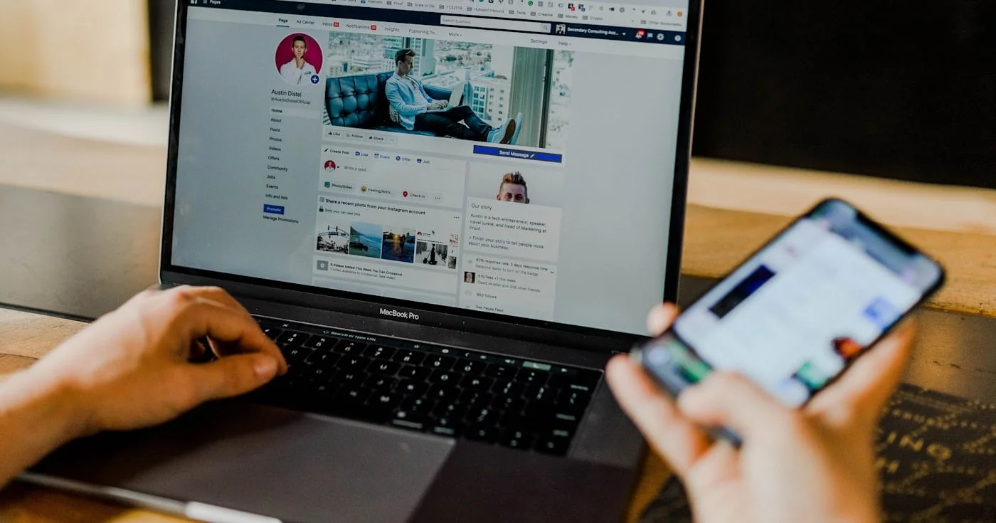 Social media manager using Facebook on a laptop and phone